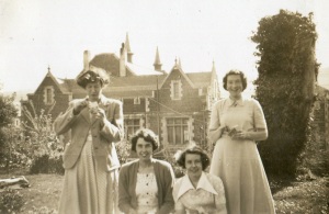 Home science students in the front garden of St Anne's, with Allen Hall in the background, 1951. Left to right - Connie Matthewson, Nona Collis, Shirley Wilson, Prue Corkhill. Unidentified sunbathing legs on the left. Photograph courtesy of Sadie Andrews.