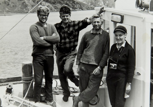 Marine biologist Betty Batham aboard the Munida with its crew in the late 1960s. Left to right - Les Tubman (crew, technician), Bill Tubman (skipper), Stan Deans (crew, cook), Dr Batham. Image courtesy of the Hocken Collections. From an album compiled by Bill Tubman, Department of Marine Science records, MS-3302/357, S14-512a.