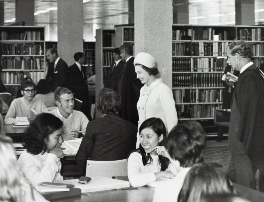 The Queen chats to students in the university library. In the background the Duke of Edinburgh does likewise. Photograph courtesy of the Hocken Collections, University of Otago Registry records, AG-180-072/021, S14-561c.