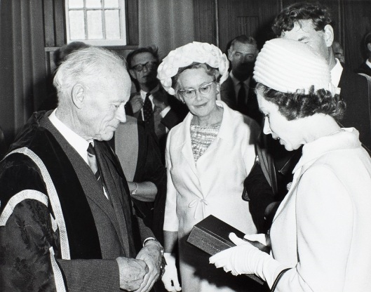 University Chancellor Hubert Ryburn presented to the Queen a specially-bound copy of the centenary history and centenary record. Looking on is his wife Jocelyn Ryburn, Warden of St Margaret's College. University of Otago Registry records, AG-180-072/021, S14-561d.
